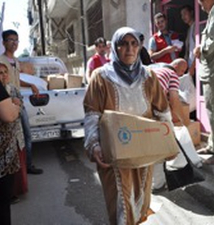 Una donna siriana con una scatola di aiuti.